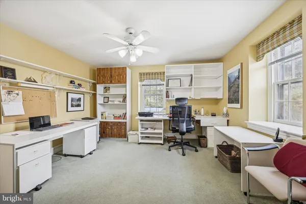 a view of a livingroom with workspace and a window