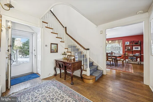a dining room with wooden floor and a rug