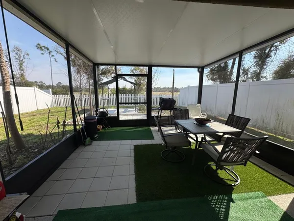 a living room with patio furniture and a flat screen tv