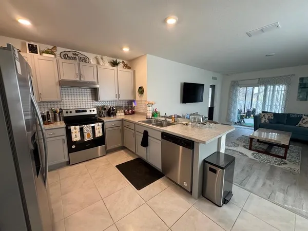 a kitchen with stainless steel appliances kitchen island granite countertop a refrigerator and a stove top oven