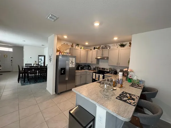 a kitchen with a refrigerator and a dining table