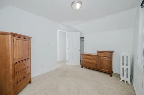 an empty room with a refrigerator and cabinets
