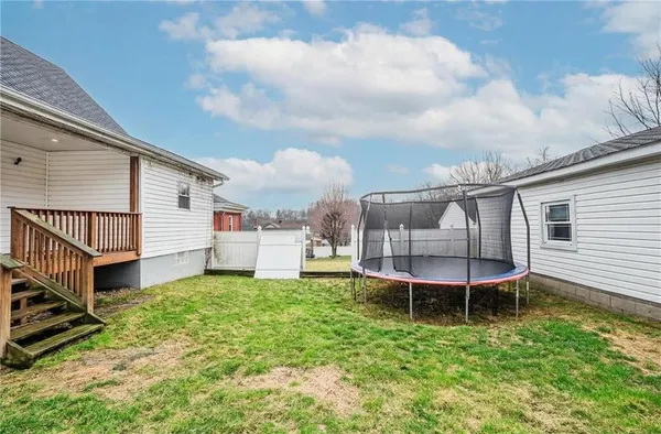 a view of a chair and table in backyard of the house