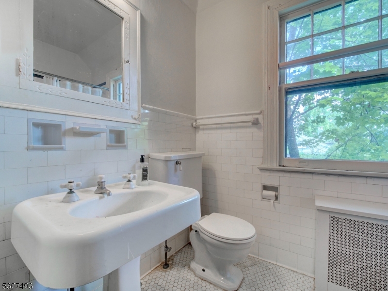 449 Grove Street Montclair, NJ 07043 - Photo 17 of 23 a bathroom with a sink a toilet and a mirror