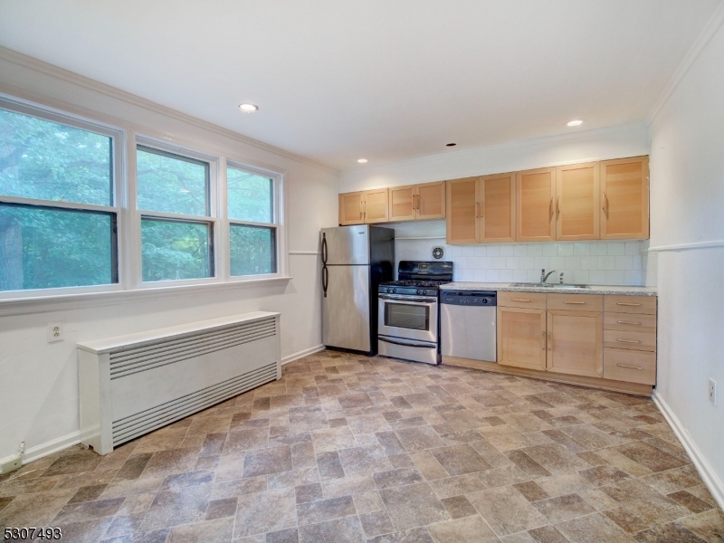 449 Grove Street Montclair, NJ 07043 - Photo 8 of 23 a kitchen with stainless steel appliances kitchen island granite countertop a sink and cabinets