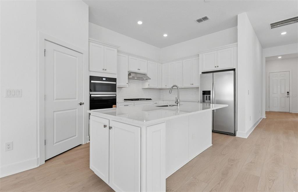 1683 Valier Point Zephyrhills, FL 33541 - Photo 2 of 20 a kitchen with stainless steel appliances a refrigerator sink and cabinets