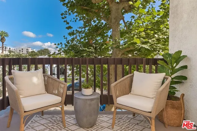 a balcony with wooden floor and outdoor seating