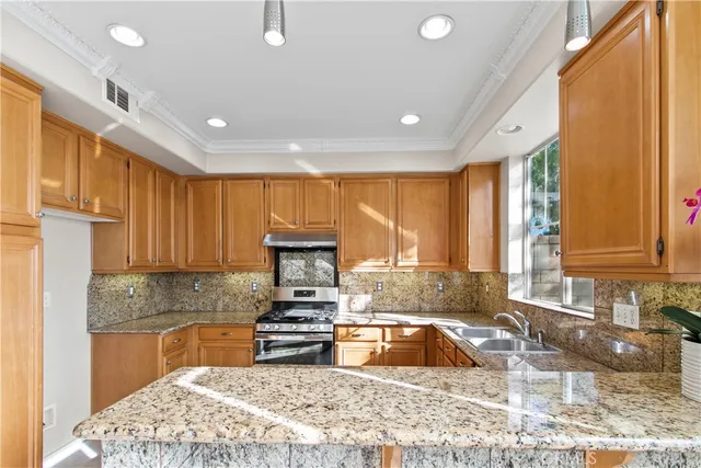 a kitchen with a sink stove top oven and cabinets