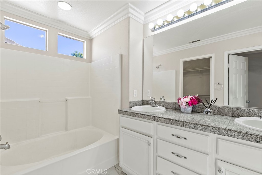6837 Cosmos Street Chino, CA 91710 - Photo 20 of 36 a bathroom with a granite countertop sink mirror and bathtub