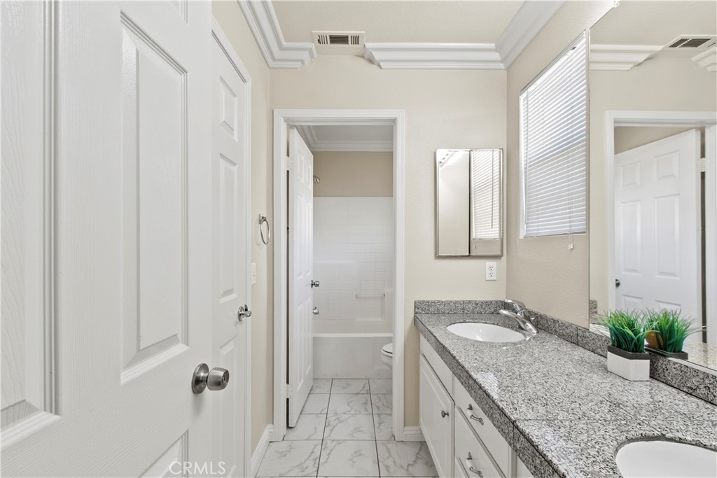 6837 Cosmos Street Chino, CA 91710 - Photo 26 of 36 a bathroom with a granite countertop sink and a mirror