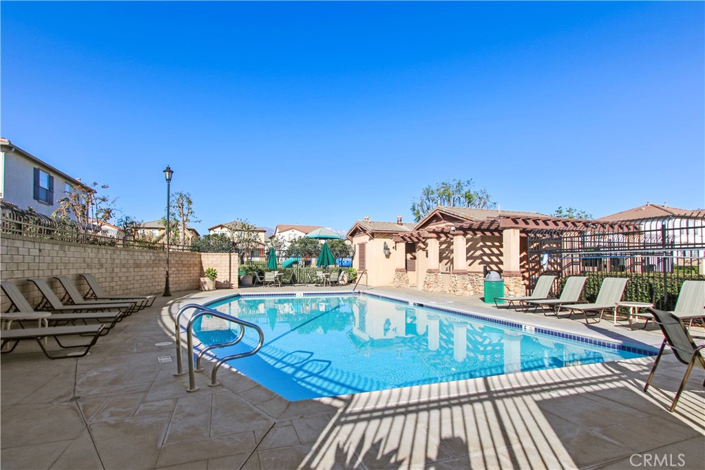 6837 Cosmos Street Chino, CA 91710 - Photo 34 of 36 a view of swimming pool with outdoor seating and buildings in the background