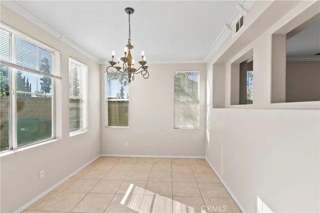 a view of a livingroom with a chandelier fan and windows