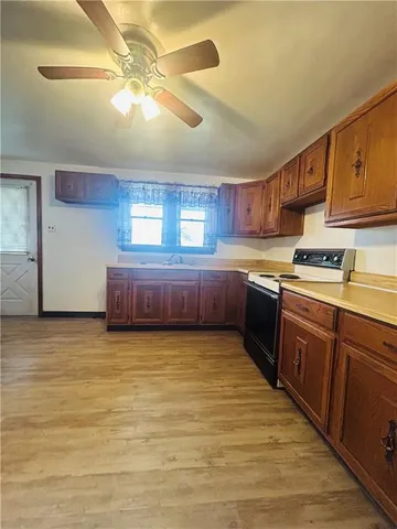 a kitchen with stainless steel appliances granite countertop a sink cabinets and wooden floor