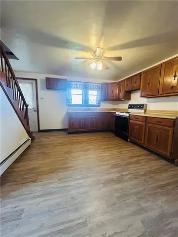 a large kitchen with wooden floors and stainless steel appliances
