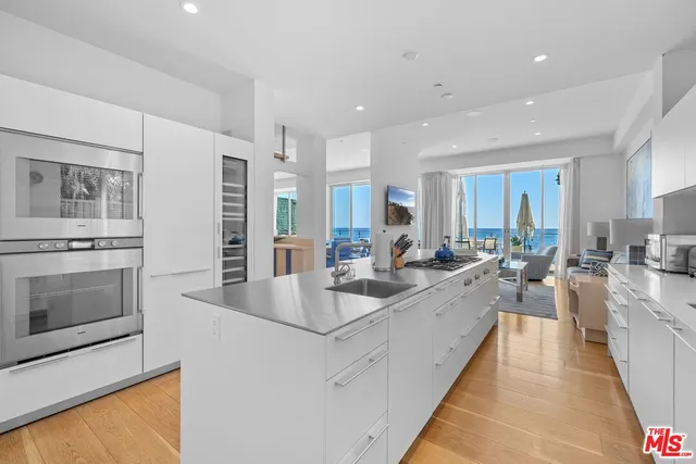 a large white kitchen with stainless steel appliances