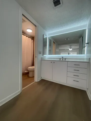 a spacious bathroom with a granite countertop sink and a mirror