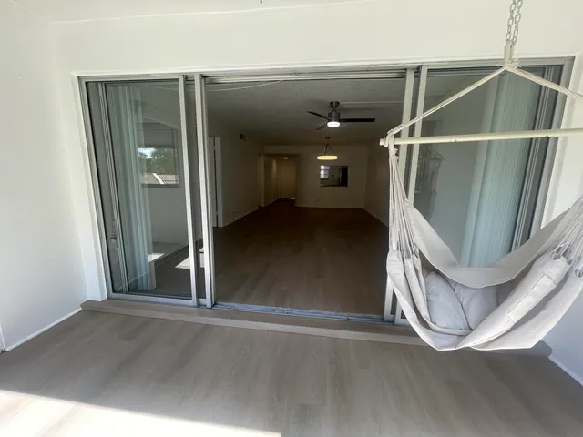 an empty room with wooden floor and a hallway
