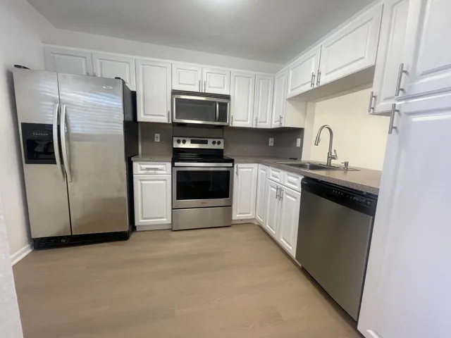 a kitchen with stainless steel appliances a refrigerator sink and microwave