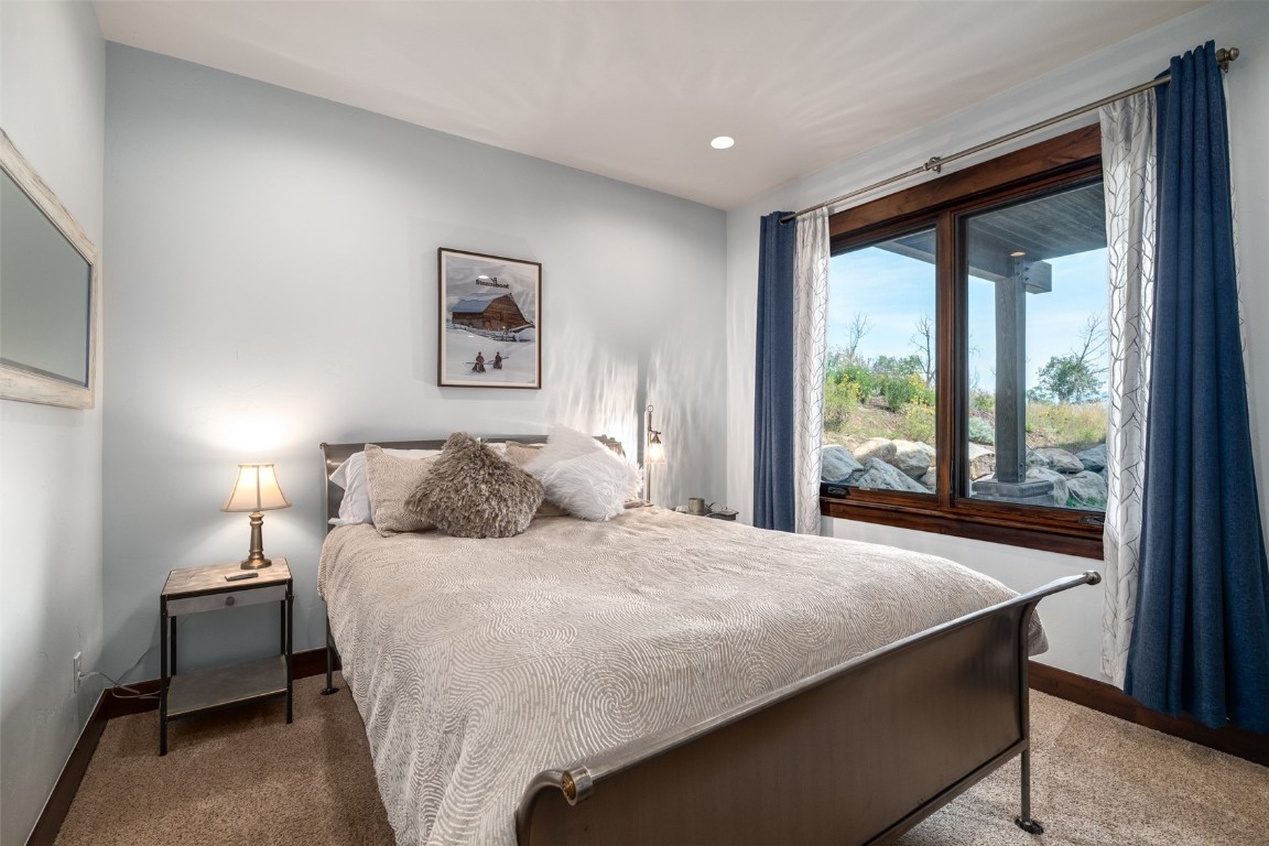 28100 Columbine Ridge Road Steamboat Springs, CO 80487 - Photo 31 of 43 a bedroom with a large bed and a large window