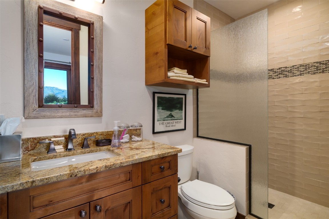 28100 Columbine Ridge Road Steamboat Springs, CO 80487 - Photo 32 of 43 a bathroom with a granite countertop toilet sink and mirror