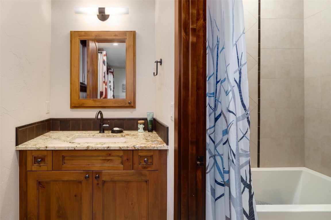 28100 Columbine Ridge Road Steamboat Springs, CO 80487 - Photo 34 of 43 a bathroom with a granite countertop sink and a mirror
