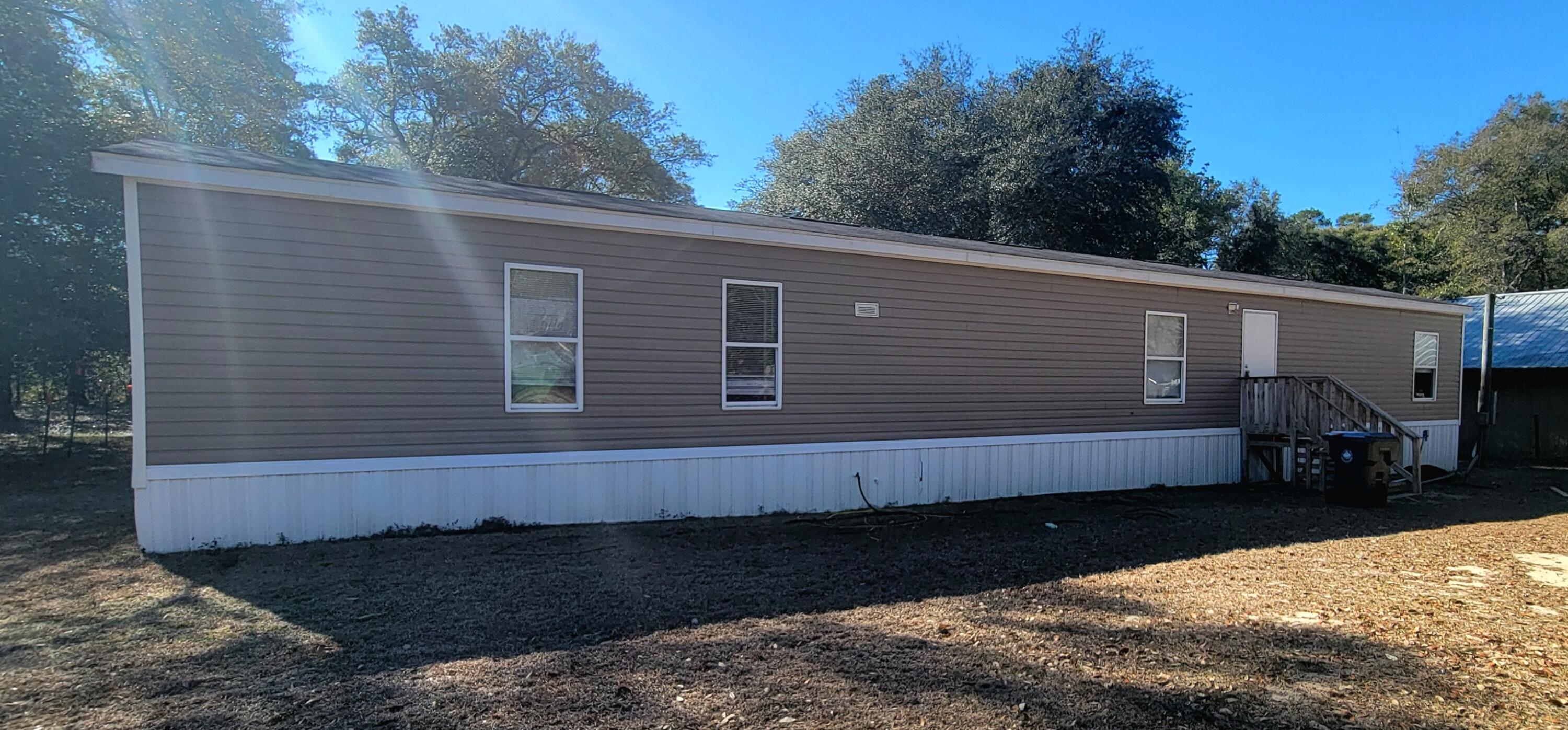 188 O'Daniels Way DeFuniak Springs, FL 32433 - Photo 2 of 17 a front view of a house with a yard