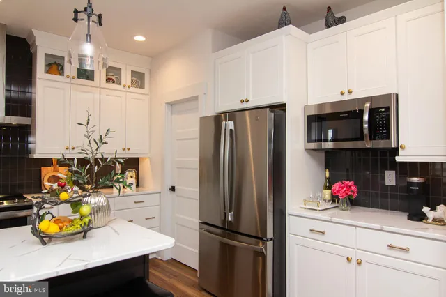 a kitchen with stainless steel appliances granite countertop a refrigerator and a stove top oven