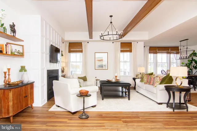 a living room with furniture kitchen view and a chandelier