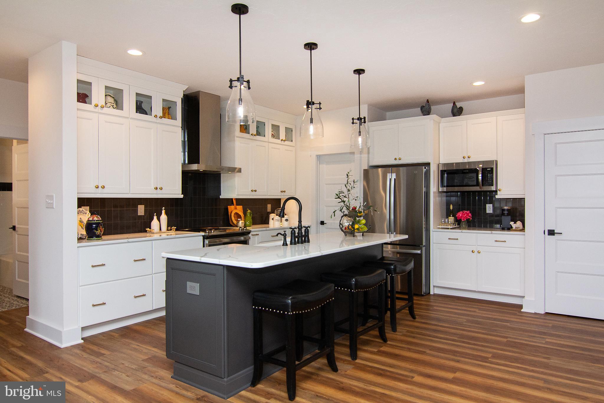 P39 Schalk Road Manchester, MD 21102 - Photo 8 of 20 a kitchen with stainless steel appliances kitchen island granite countertop a sink a stove a refrigerator and white cabinets with wooden floor