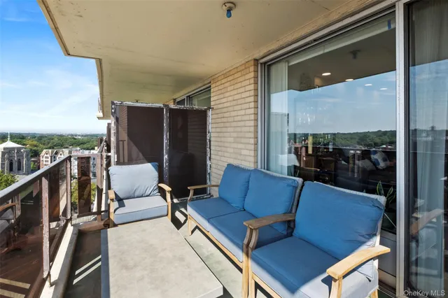 a living room with couches a coffee table and chandelier with outer view