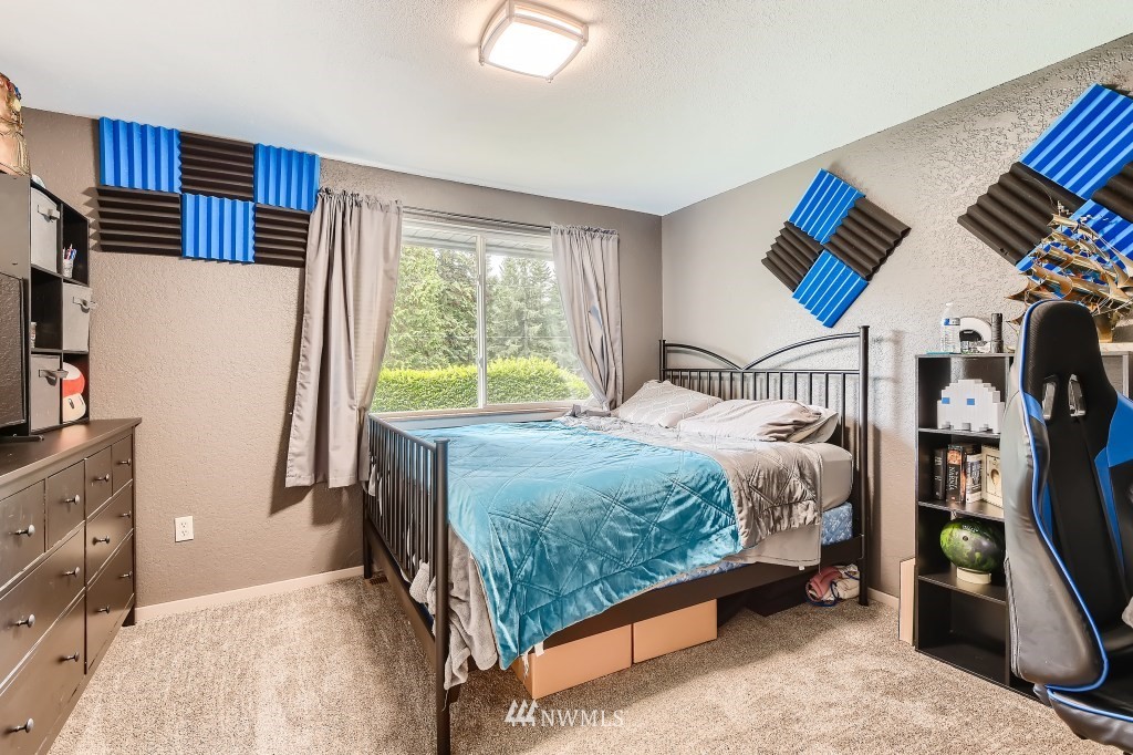 22420 61st Avenue Southeast Bothell, WA 98021 - Photo 18 of 39 a bedroom with a bed and a refrigerator
