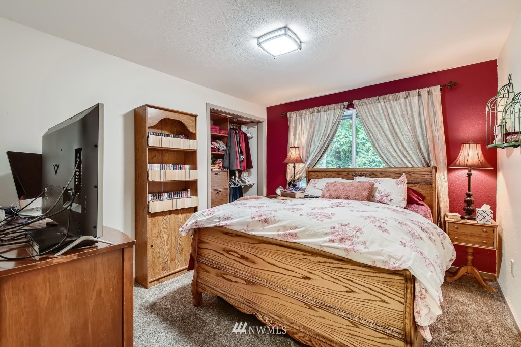 22420 61st Avenue Southeast Bothell, WA 98021 - Photo 19 of 39 a bedroom with a bed and a flat screen tv
