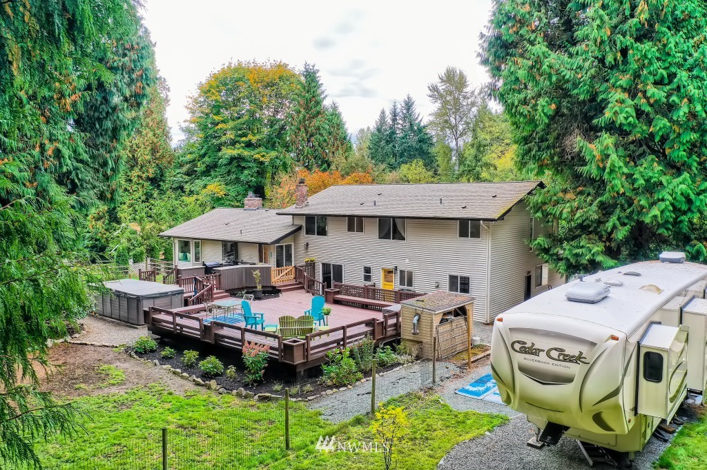 22420 61st Avenue Southeast Bothell, WA 98021 - Photo 34 of 39 a backyard of a house with table and chairs under an umbrella