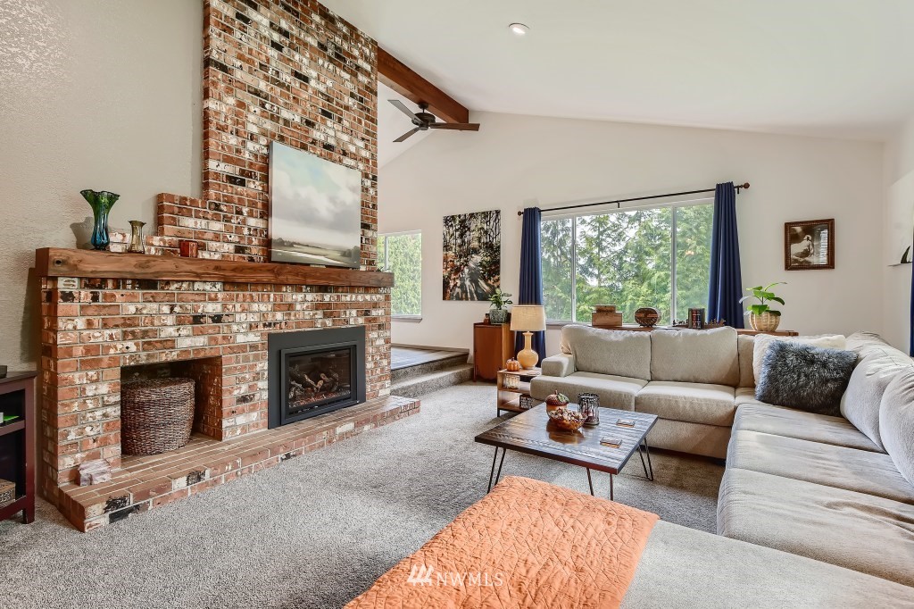 22420 61st Avenue Southeast Bothell, WA 98021 - Photo 5 of 39 a living room with furniture a fireplace and a large window