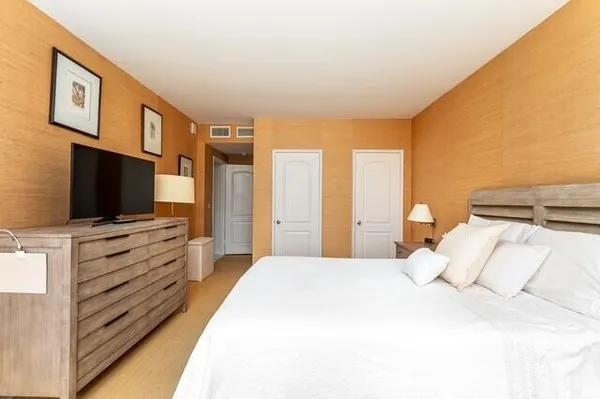 a large bedroom with a bed and flat screen tv