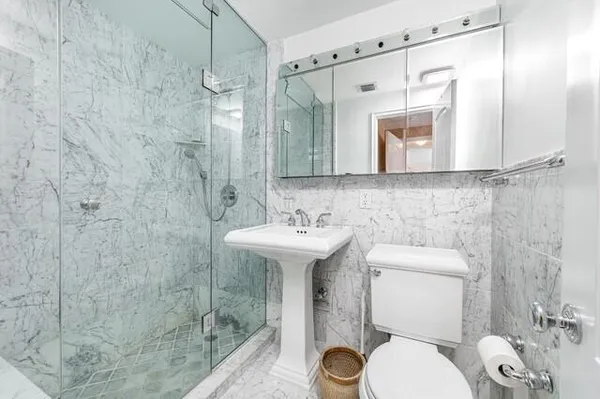 a bathroom with a sink a toilet and shower