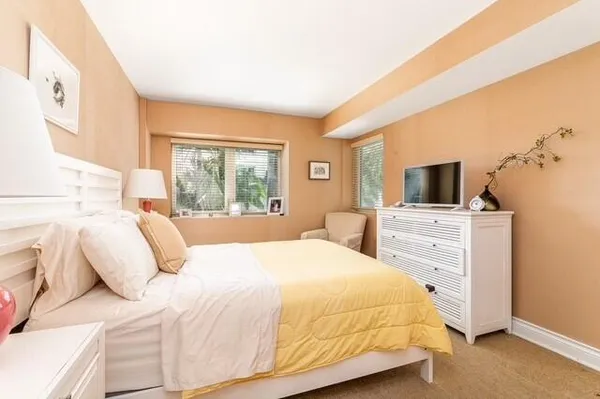 a bedroom with a large bed and flat tv screen
