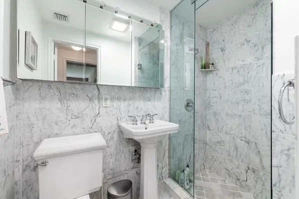 a bathroom with a sink a toilet and shower