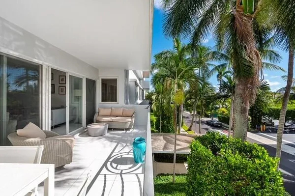 a view of a patio with table and chairs potted plants and palm tree