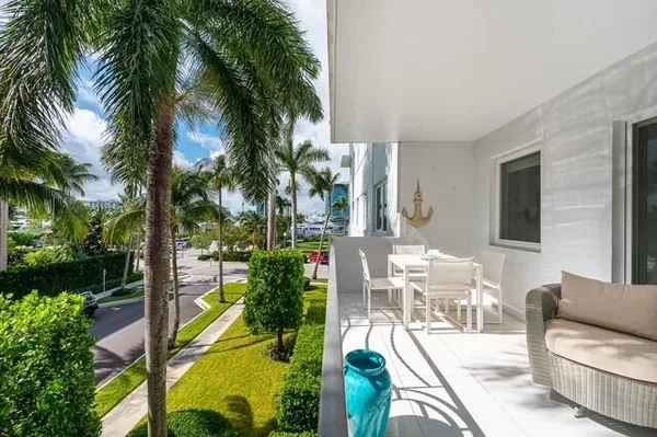a view of a patio with couches table and chairs potted plants and palm tree