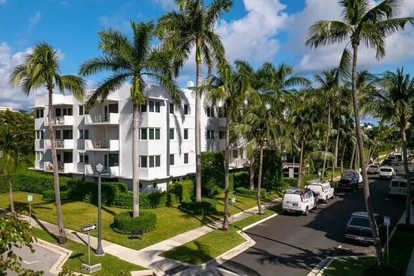 a front view of a multi story building with a palm tree