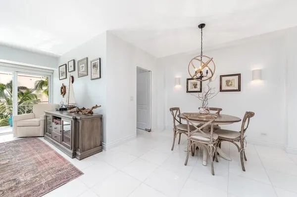 a view of a dining room and livingroom with furniture wooden floor a chandelier