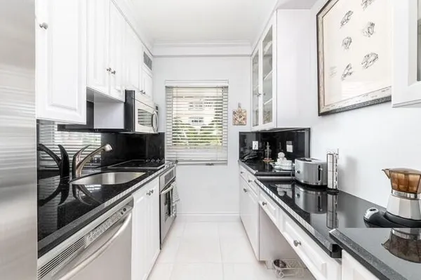 a kitchen with stainless steel appliances a stove a sink and a microwave