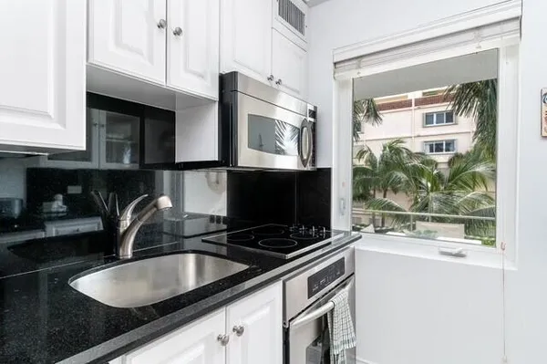 a kitchen with a sink cabinets and a wooden floor