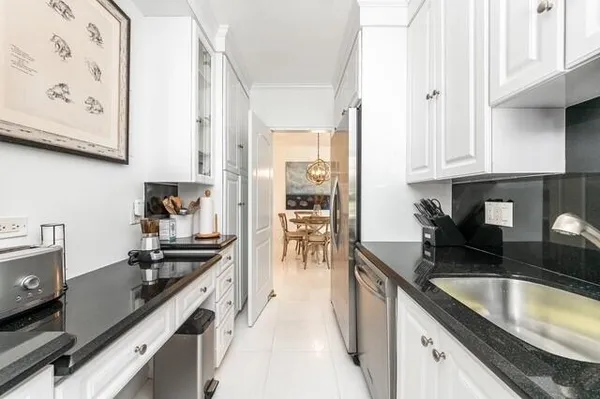 a kitchen with granite countertop a sink stove and cabinets
