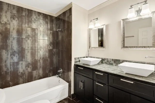 a bathroom with a granite countertop sink and a bathtub