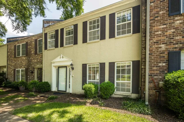 a front view of a house having yard and potted plants
