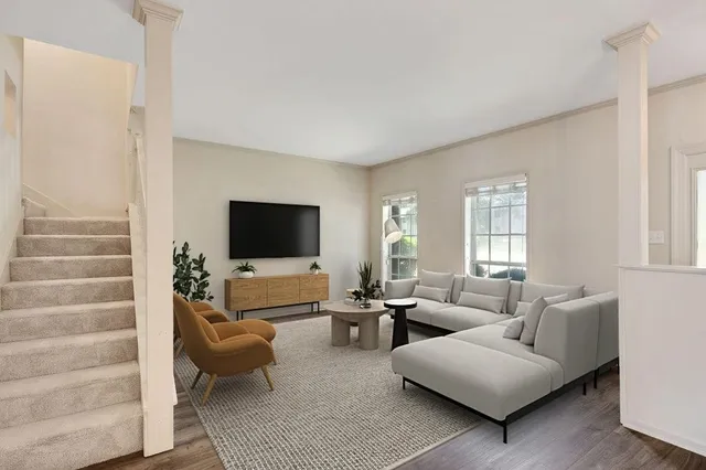 a living room with furniture wooden floor and a flat screen tv