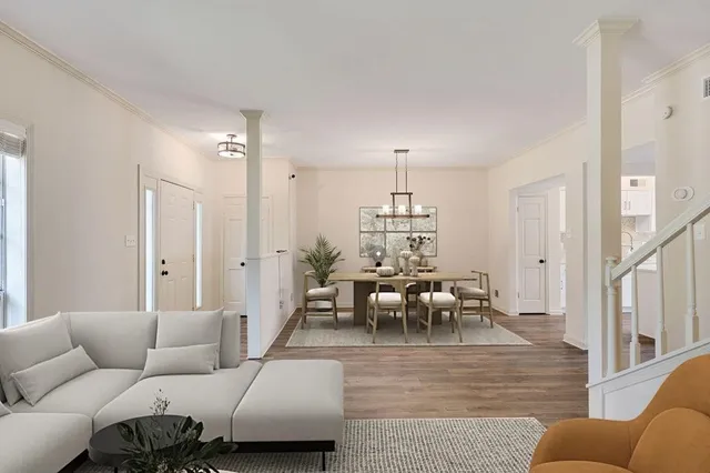 a living room with furniture kitchen view and a wooden floor