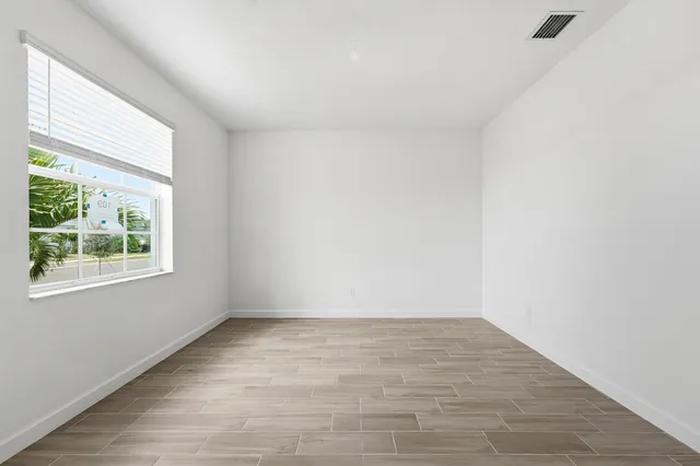 wooden floor in an empty room with a window